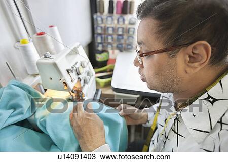 Side view of male tailor stitching cloth on sewing machine View Large Photo Image Stock Image - Side view of male tailor stitching cloth on sewing machine. Fotosearch