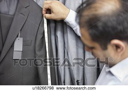 Stock Photo - Tailor measuring suit's sleeve. Fotosearch
