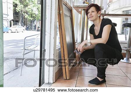 Thoughtful mid adult woman crouching at doorway View Large Photo Image Stock Photography - Thoughtful mid adult woman crouching at doorway. Fotosearch