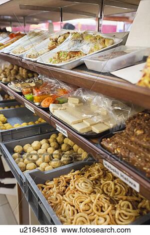Stock Photo - Variety of Indian sweet food displayed at store. Fotosearch
