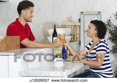 Woman handing over empty glass to male waiter at counter View Large Photo Image Stock Photo - Woman handing over empty glass to male waiter at counter. Fotosearch