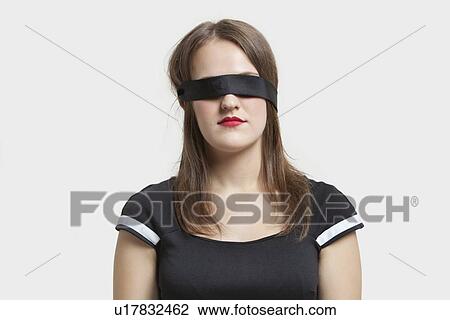 Young blindfolded woman against gray background View Large Photo Image Stock Image - Young blindfolded woman against gray background. Fotosearch