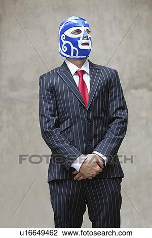 Young businessman in pinstripes suit and wrestling mask looking away over gray background View Large Photo Image Stock Image - Young businessman in pinstripes suit and wrestling mask looking away over gray background. Fotosearch