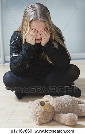 Young girl sitting on floor with hands on eyes View Large Photo Image Stock Image - Young girl sitting on floor with hands on eyes. Fotosearch