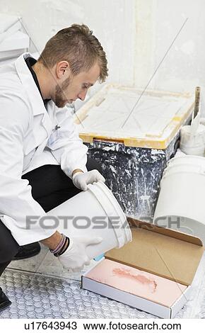 Young male technician pouring PlatSil Gel on footprint View Large Photo Image Stock Image - Young male technician pouring PlatSil Gel on footprint. Fotosearch