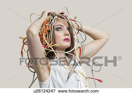 Young woman with head tangled in colorful cables over gray background View Large Photo Image Stock Photo - Young woman with head tangled in colorful cables over gray background. Fotosearch