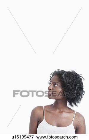 Stock Photo - African American young woman looking up against white background. Fotosearch