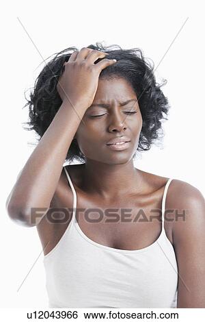 Stock Photograph - An African American young woman suffering from headache over white background. Fotosearch