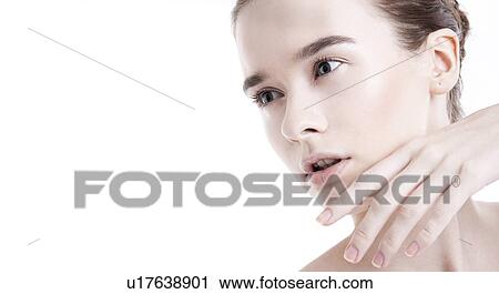 Stock Image - Beautiful young woman posing against white background. Fotosearch