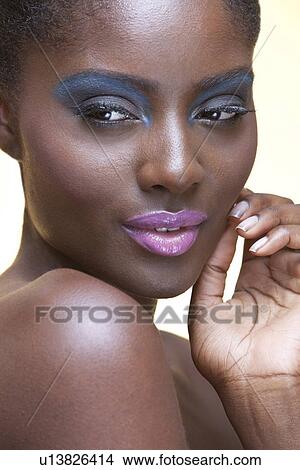 Picture - Close-up of a beautiful young woman with blue eye shadow and pink lipstick. Fotosearch