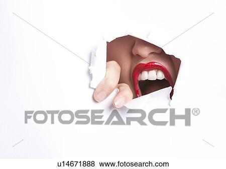Close-up of furious young woman with red lips trying to break free from paper wall View Large Photo Image Stock Photo - Close-up of furious young woman with red lips trying to break free from paper wall. Fotosearch