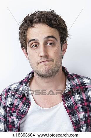Picture - Close-up portrait of a bored young man against white background. Fotosearch