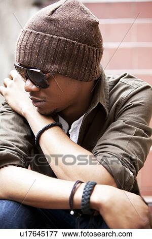 Stock Photo - Close-up Portrait of a seated young African American man. Fotosearch