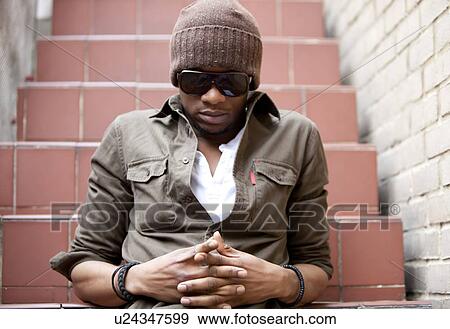 Close-up Portrait of a young African American man sitting on outdoor steps View Large Photo Image Stock Photo - Close-up Portrait of a young African American man sitting on outdoor steps. Fotosearch