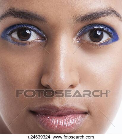 Close-up portrait of beautiful young woman with blue eyeshadow against white background View Large Photo Image Picture - Close-up portrait of beautiful young woman with blue eyeshadow against white background. Fotosearch