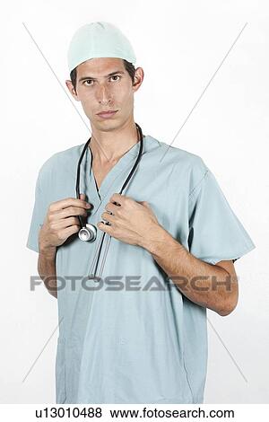 Close-up portrait of young doctor wearing scrubs and standing proudly View Large Photo Image Stock Photo - Close-up portrait of young doctor wearing scrubs and standing proudly. Fotosearch