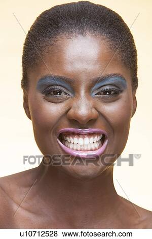 Close-up view of beautiful woman wearing make-up showing her teeth View Large Photo Image Stock Photo - Close-up view of beautiful woman wearing make-up showing her teeth. Fotosearch