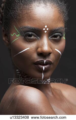 Stock Photo - Close-up view of beautiful woman wearing tribal make-up paint. Fotosearch