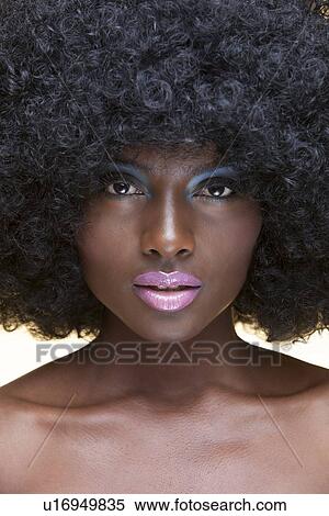 Stock Photography - Close-up view of beautiful woman with afro wearing make-up. Fotosearch