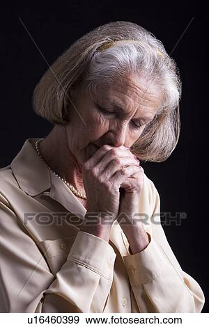 Stock Photo - Emotional Portrait of Senior woman praying. Fotosearch