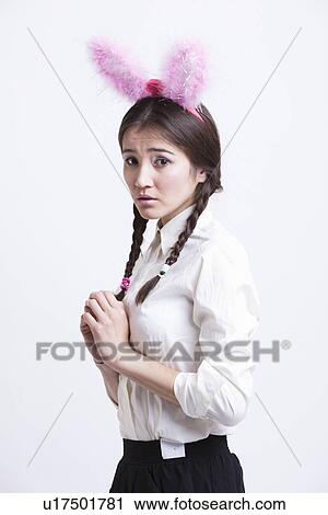 Frightened young woman with bunny ears against white background View Large Photo Image Stock Image - Frightened young woman with bunny ears against white background. Fotosearch