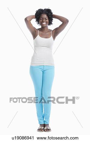 Frustrated young woman with hands behind head standing against white background View Large Photo Image Stock Image - Frustrated young woman with hands behind head standing against white background. Fotosearch