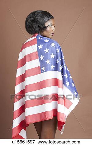 Stock Photo - Half-length rear view of young woman wearing Stars and Stripes Flag . Fotosearch