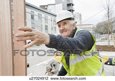 Happy senior male worker at working at construction site View Large Photo Image Stock Image - Happy senior male worker at working at construction site. Fotosearch