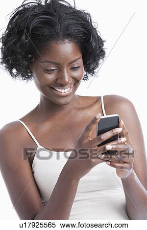 Happy young African American woman text messaging over white background View Large Photo Image Stock Photography - Happy young African American woman text messaging over white background. Fotosearch