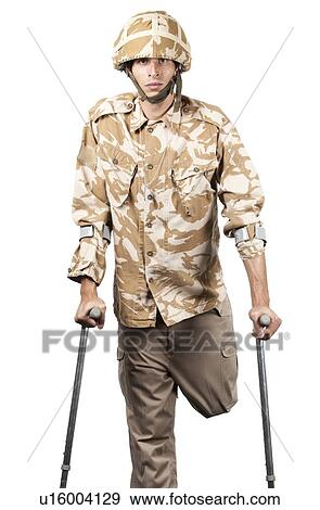 Stock Photo - Injured soldier in combat fatigues uses crutches. Fotosearch