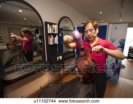 Male Korean Hair Dresser Blow dries Female customers hair View Large Photo Image Picture - Male Korean Hair Dresser Blow dries Female customers hair. Fotosearch