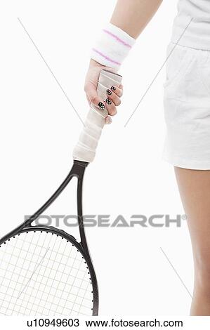 Midsection of a young Asian woman holding tennis racket over white background View Large Photo Image Stock Image - Midsection of a young Asian woman holding tennis racket over white background. Fotosearch