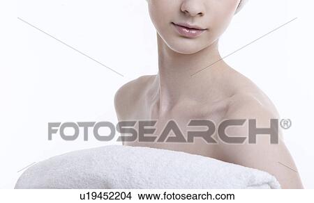 Midsection of young woman with towel against white background View Large Photo Image Picture - Midsection of young woman with towel against white background. Fotosearch