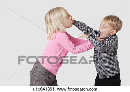 Stock Image - Playful young boy and girl over white background. Fotosearch