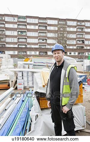Portrait of a confident worker standing at construction site View Large Photo Image Stock Image - Portrait of a confident worker standing at construction site. Fotosearch