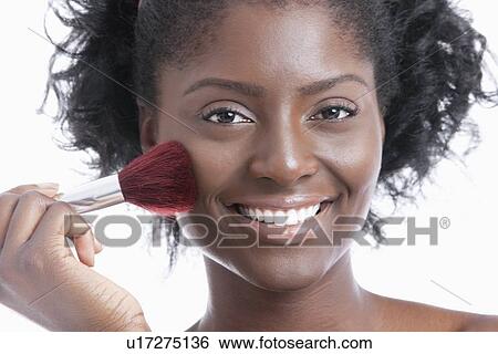 Portrait of a happy young woman applying blush over white background View Large Photo Image Stock Photograph - Portrait of a happy young woman applying blush over white background. Fotosearch