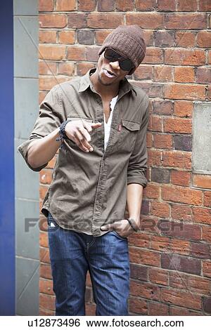 Portrait of a young African American man standing against brick wall View Large Photo Image Stock Photograph - Portrait of a young African American man standing against brick wall. Fotosearch