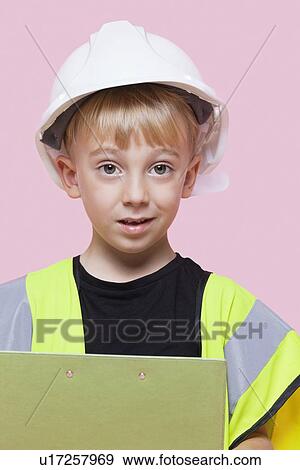 Portrait of a young boy pretending at construction worker over pink background View Large Photo Image Stock Photo - Portrait of a young boy pretending at construction worker over pink background. Fotosearch