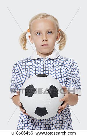 Portrait of a young girl holding soccer ball over white background View Large Photo Image Stock Photograph - Portrait of a young girl holding soccer ball over white background. Fotosearch