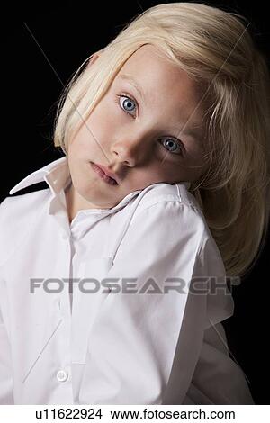Portrait of a young girl loking to camera against a black background View Large Photo Image Picture - Portrait of a young girl loking to camera against a black background. Fotosearch