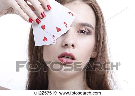 Portrait of beautiful young woman covering her eyes with playing cards against white background View Large Photo Image Stock Photo - Portrait of beautiful young woman covering her eyes with playing cards against white background. Fotosearch