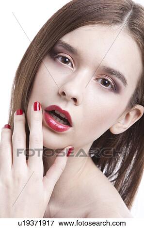 Portrait of beautiful young woman wearing red lipstick with hand on face against white background View Large Photo Image Stock Photo - Portrait of beautiful young woman wearing red lipstick with hand on face against white background. Fotosearch