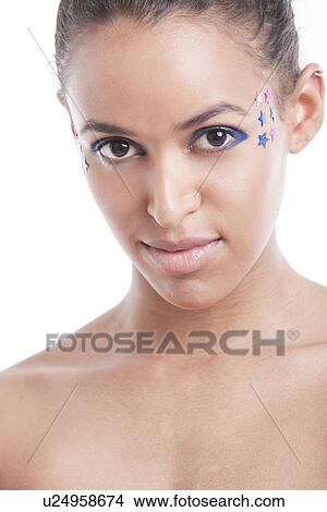 Picture - Portrait of beautiful young woman with blue eyeshadow and stars on face against white background. Fotosearch