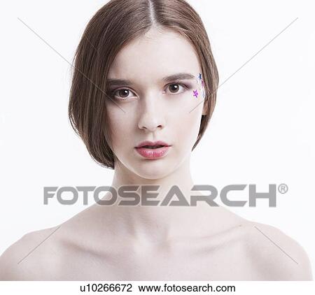 Stock Image - Portrait of beautiful young woman with stars on her face against white background. Fotosearch