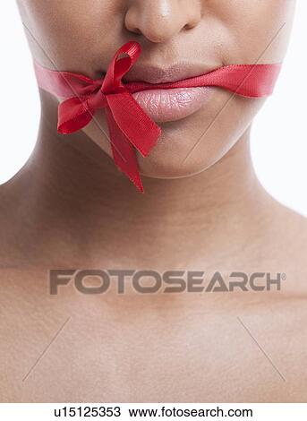 Stock Image - Portrait of beautiful young woman with blue eyeshadow against white background. Fotosearch