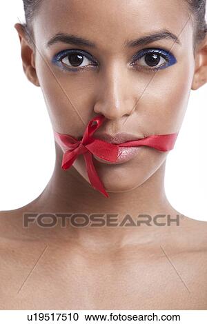 Portrait of beautiful young woman with ribbon tied over her mouth against white background View Large Photo Image Stock Image - Portrait of beautiful young woman with ribbon tied over her mouth against white background. Fotosearch