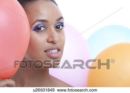 Portrait of beautiful young woman with balloons against white background View Large Photo Image Stock Photo - Portrait of beautiful young woman with balloons against white background. Fotosearch
