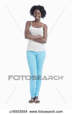 Picture - Portrait of confident young woman with arms crossed standing against white background. Fotosearch