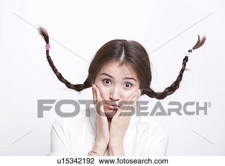 Portrait of confused young woman with braids curling upwards against white background View Large Photo Image Stock Image - Portrait of confused young woman with braids curling upwards against white background. Fotosearch