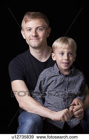Portrait of happy father and son in casuals with arms crossed over black background View Large Photo Image Stock Photo - Portrait of happy father and son in casuals with arms crossed over black background. Fotosearch